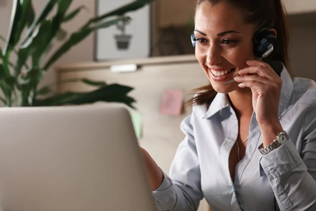 Mortgages Kansas - happy customer service representative talking with customer while using laptop office Mortgages Kansas - happy customer service representative talking with customer while using laptop office